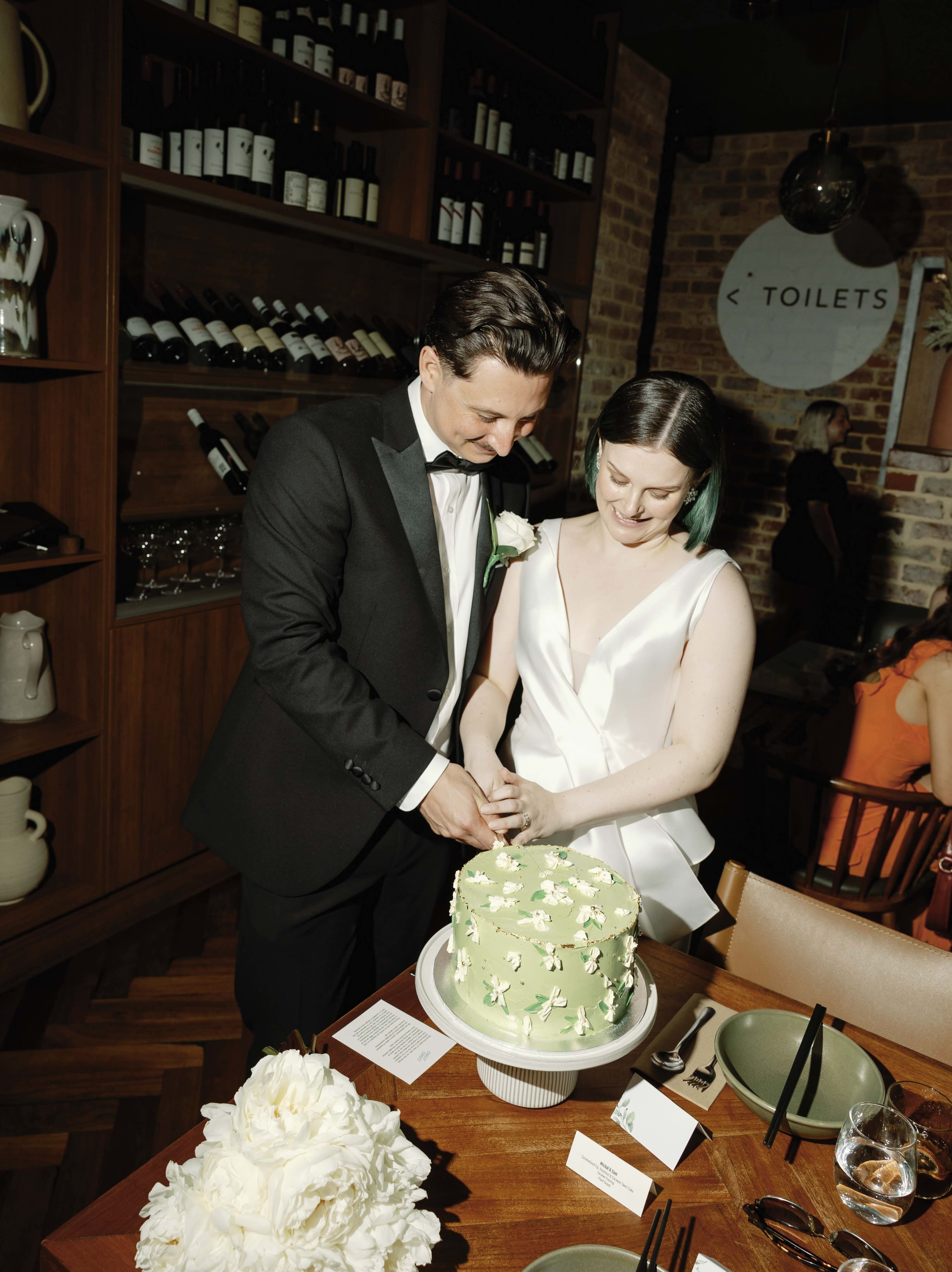 Wedding Couple in Perth Cutting a green floral decorated cake.