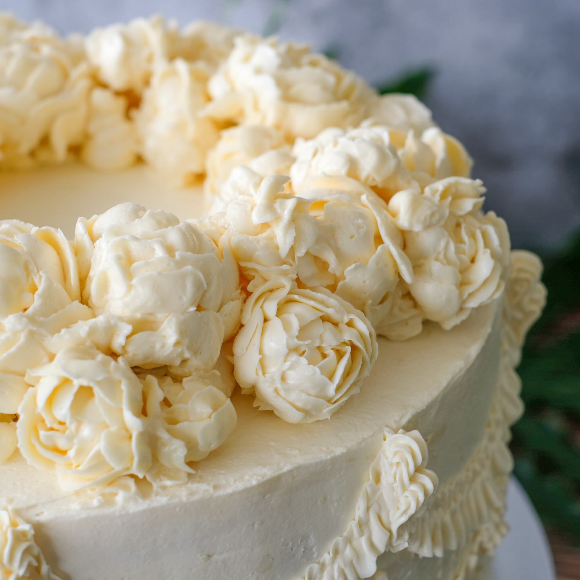 Close-up of a cake with white frosting and floral designs