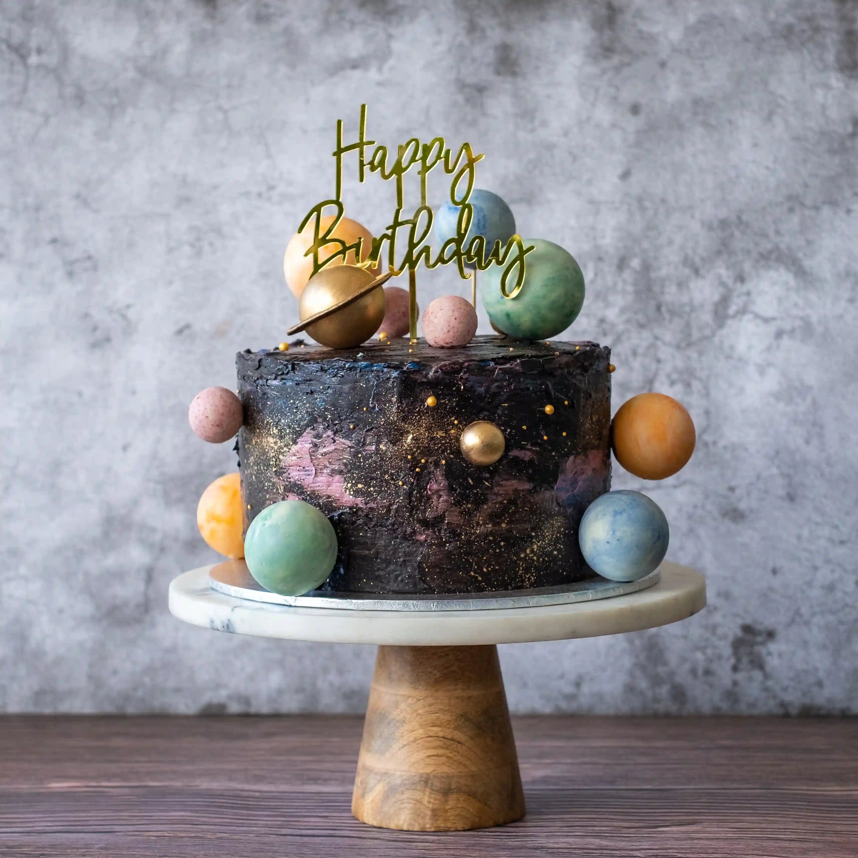 Birthday cake with space-themed decorations with a birthday cake topper