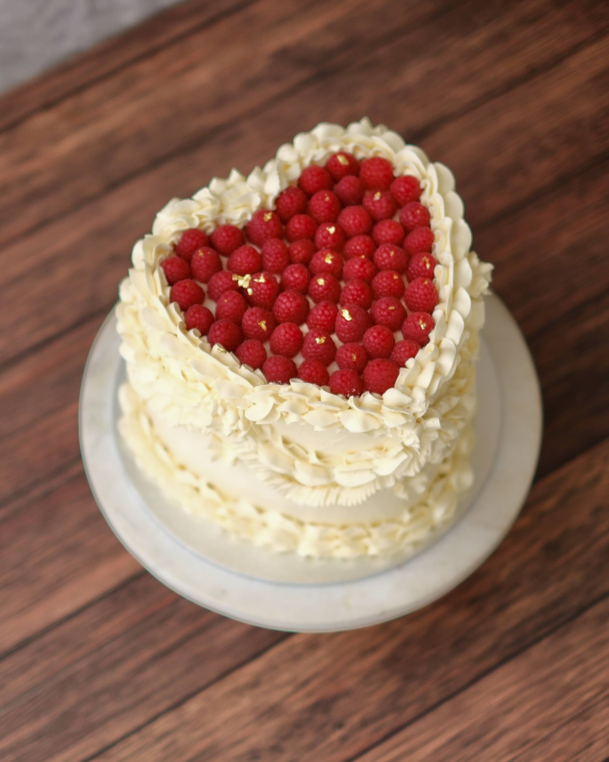 overhead image of a heart-shaped raspberry design with vintage piped buttercream dairy free gluten free optional.