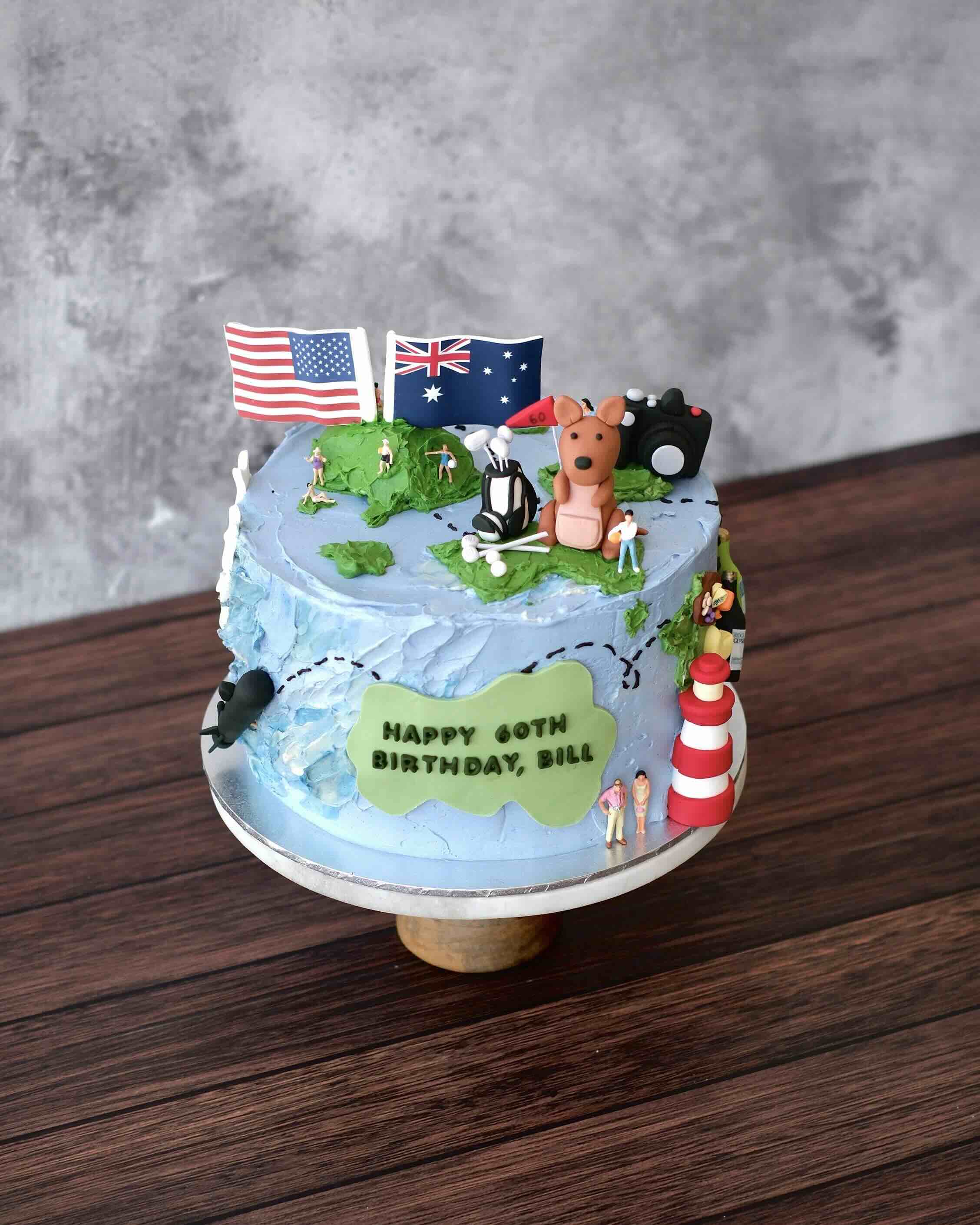 A custom cake decorated as a globe with edible decorations filled with the customer's favourite hobbies.